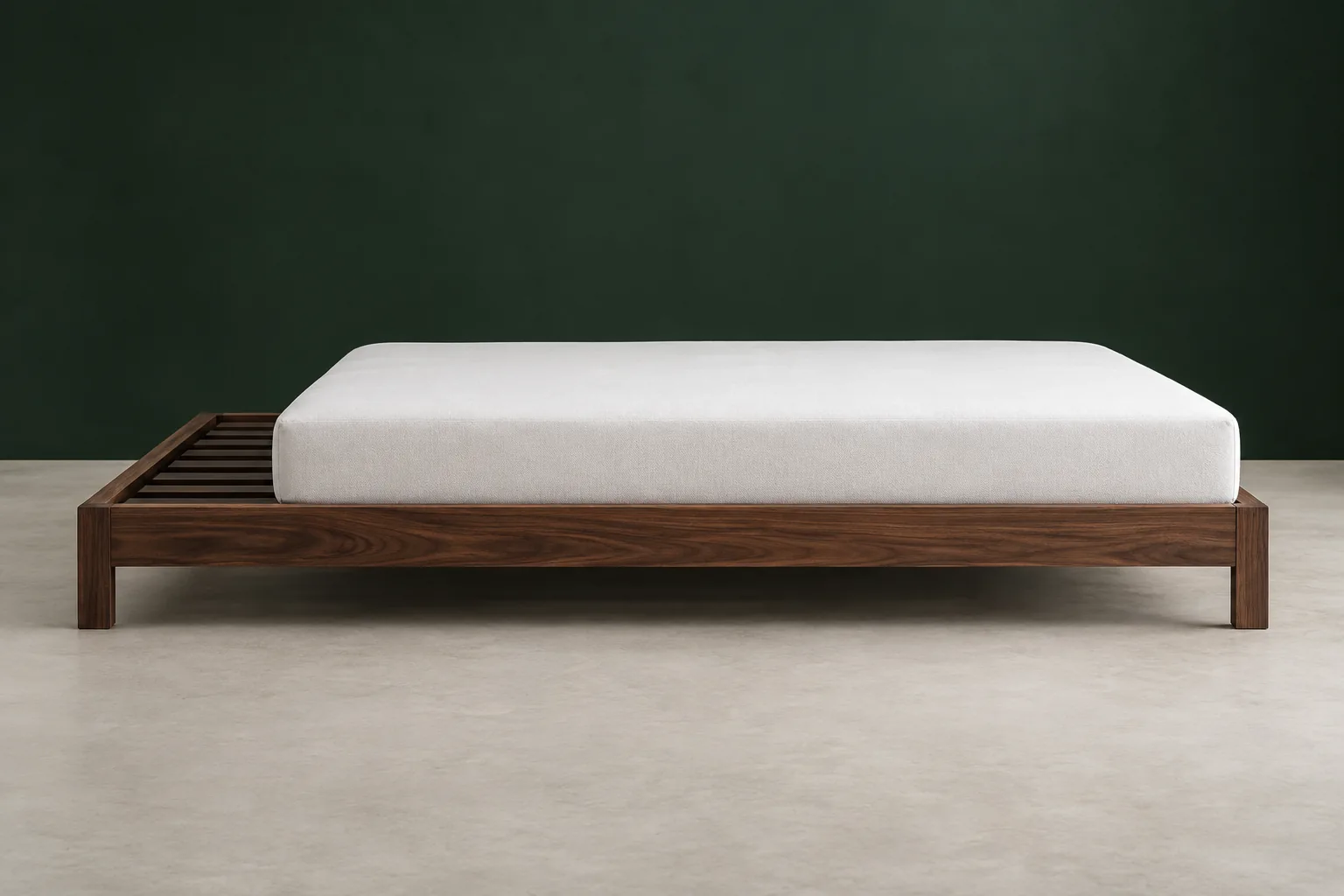 Walnut platform bed with exposed recessed slats beside a white mattress, showing the support surface below the side-rail top